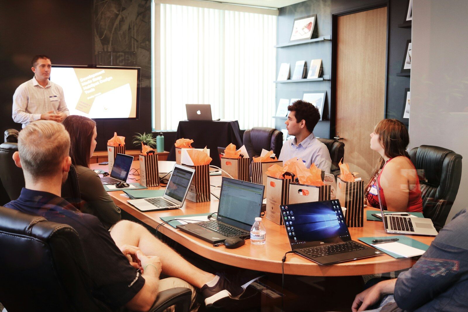 a group of people sitting around a laptop computer